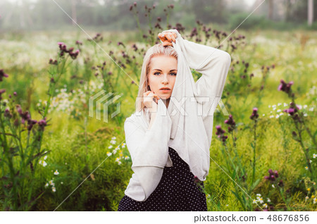 Portrait of young girl dancing in chamomile field Portrait of young girl dancing in chamomile field 48676856