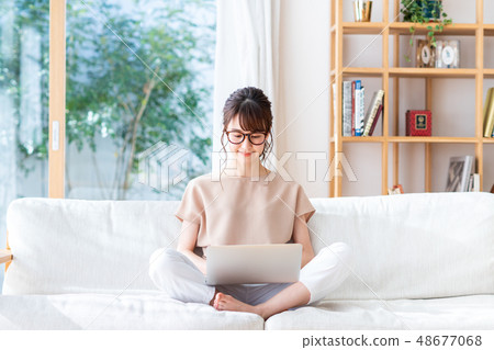 操作一台個人計算機的少婦在客廳 操作一台個人計算機的少婦在客廳 48677068