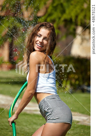Beautiful young woman having fun in summer garden Beautiful young woman having fun in summer garden 48678121