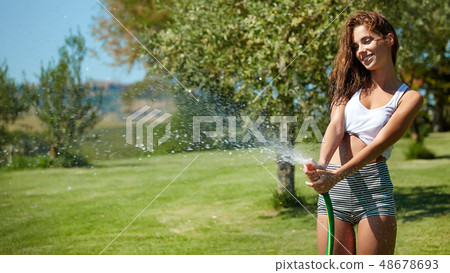 Beautiful young woman having fun in summer garden 48678693
