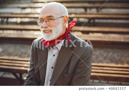 Elegant old man in a sunny autumn park Elegant old man in a sunny autumn park 48681557