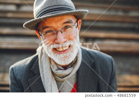 Elegant old man in a sunny autumn park Elegant old man in a sunny autumn park 48681559
