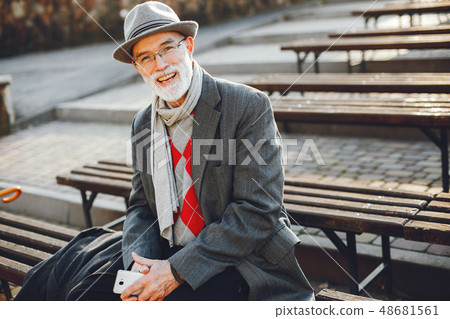 Elegant old man in a sunny autumn park Elegant old man in a sunny autumn park 48681561