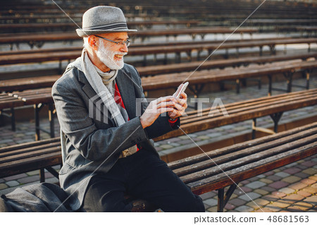 Elegant old man in a sunny autumn park Elegant old man in a sunny autumn park 48681563