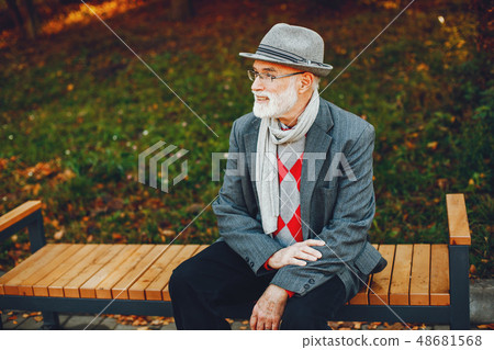 Elegant old man in a sunny autumn park  48681568