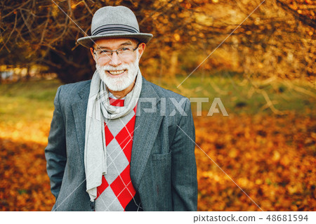 Elegant old man in a sunny autumn park  48681594