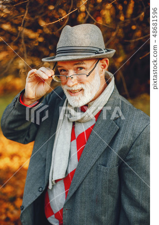 Elegant old man in a sunny autumn park  48681596