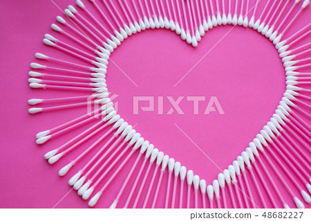 cotton buds laid out in the shape of a heart on a 48682227