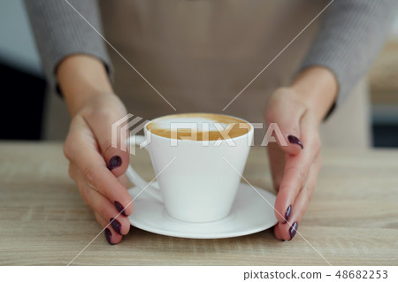 Barista in apron in coffee shop give just brewed Barista in apron in coffee shop give just brewed 48682253