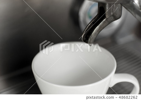 empty white cup set in coffee machine awaits hot empty white cup set in coffee machine awaits hot 48682262