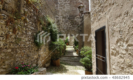 Path between stone walls and houses in Italy Path between stone walls and houses in Italy 48682945