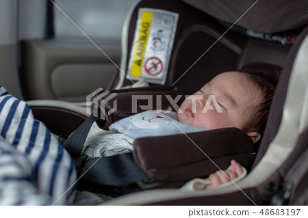 Baby sleeping on a child seat Baby sleeping on a child seat 48683197