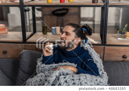 Unhappy brunette young man suffering from cold Unhappy brunette young man suffering from cold 48683265