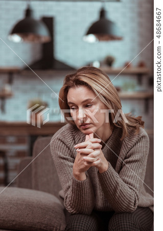 Blonde-haired housewife sitting and waiting for her husband coming home 48684667