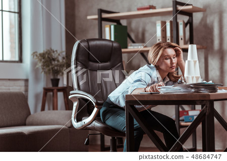 Woman wearing dark trousers and blue blouse feeling stressed Woman wearing dark trousers and blue blouse feeling stressed 48684747