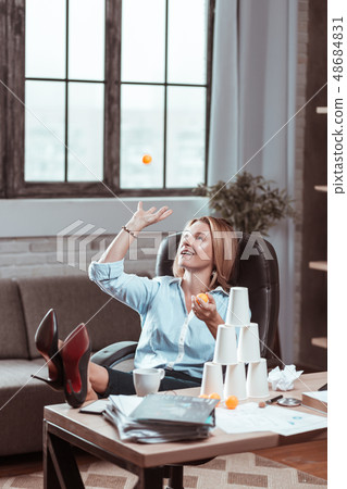 Woman going crazy at work playing with tennis ball 48684831