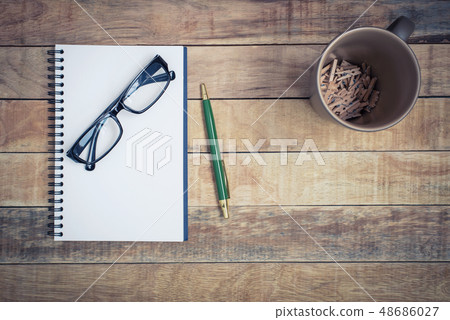 Blank notebook with pen and glasses on wood table Blank notebook with pen and glasses on wood table 48686027