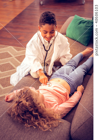 Cheerful brunette boy playing role of doctor 48686103