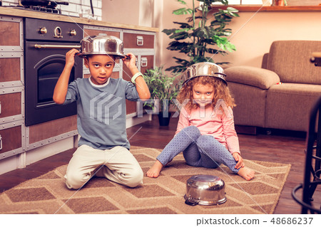Positive delighted kids playing together with kitchenware Positive delighted kids playing together with kitchenware 48686237