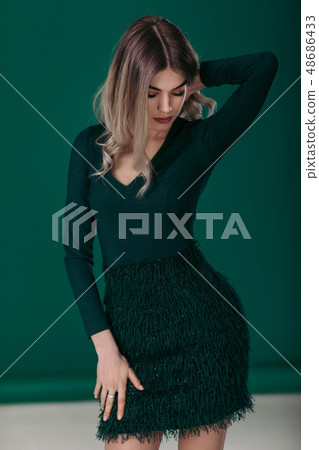 blonde woman posing in green dress on green background blonde woman posing in green dress on green background 48686433