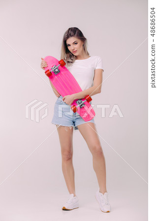 beautiful woman in white t-shirt with pink skateboard 48686504
