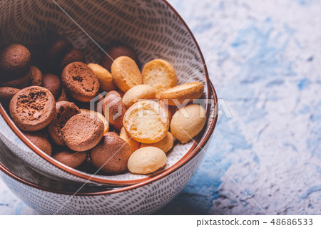 Several sponge biscuits in bowl on light wooden Several sponge biscuits in bowl on light wooden 48686533