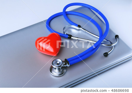 Workplace of doctor with stethoscope, red heart, laptop, rx prescription and notebook on white table 48686698