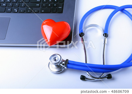 Workplace of doctor with stethoscope, red heart, laptop, rx prescription and notebook on white table 48686709