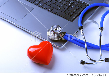 Workplace of doctor with stethoscope, red heart, laptop, rx prescription and notebook on white table 48686711