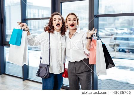 Curly daughter feeling happy after shopping with mother Curly daughter feeling happy after shopping with mother 48686766