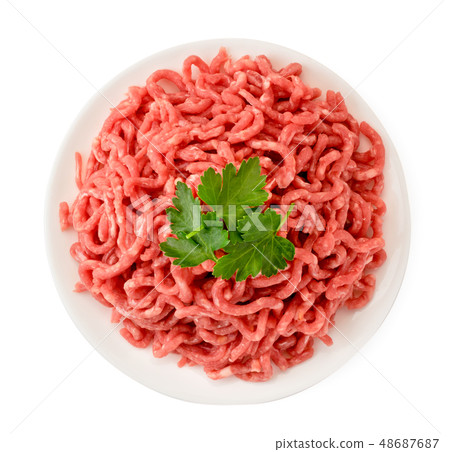 Minced meat in a plate and parsley leaves on a Minced meat in a plate and parsley leaves on a 48687687