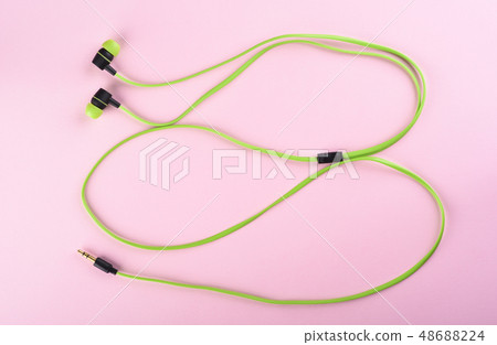 Green headphones or earphones isolated on a pink 48688224