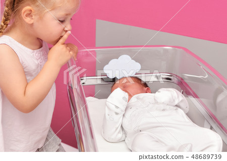 First meeting between a sister and a newborn baby in the hospital ward First meeting between a sister and a newborn baby in the hospital ward 48689739