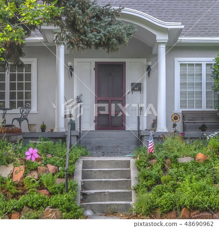Stairs leading to porch and brown door of a home 48690962