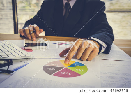 Businessman or accountant working on calculator to Businessman or accountant working on calculator to 48692736