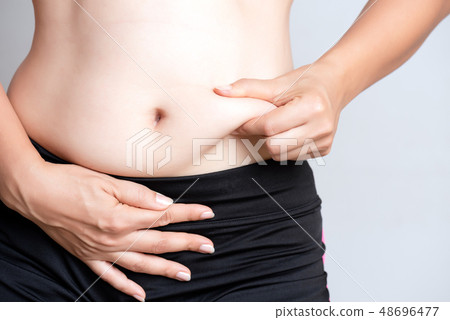 Fat woman hand holding excessive belly fat. 48696477