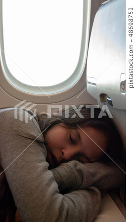 Young tween girl on airplane 48698751