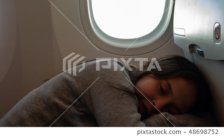 Young tween girl on airplane 48698752