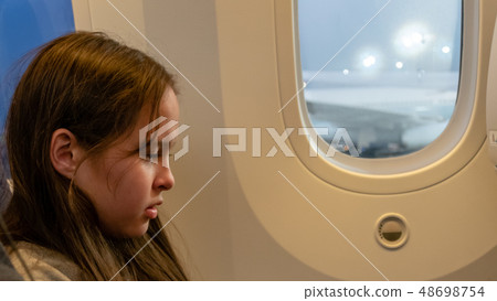 Young tween girl on airplane 48698754