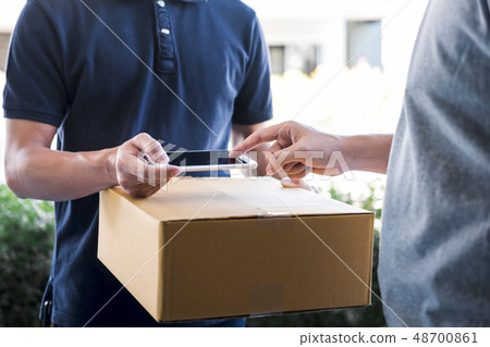 Delivery mail man giving parcel box to recipient, Young man appe 48700861