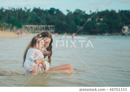 Mother with her child sitting on the sand beside Mother with her child sitting on the sand beside 48701333