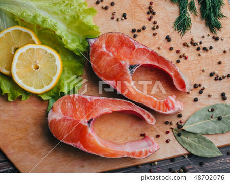 sliced pieces of fresh raw trout on Board. Red fish fillet 48702076