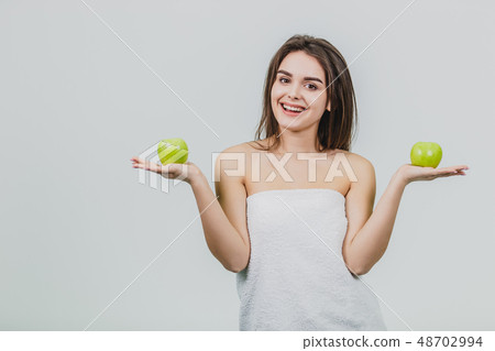 Funny laughing woman holding two green apples in her eyes. White background of a healthy eating 48702994