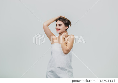 Happy, playful brunette woman on a white background. Looking at the camera while playing with her Happy, playful brunette woman on a white background. Looking at the camera while playing with her 48703431