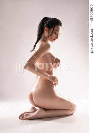 Naked brunette sitting on her knees shot 48703600