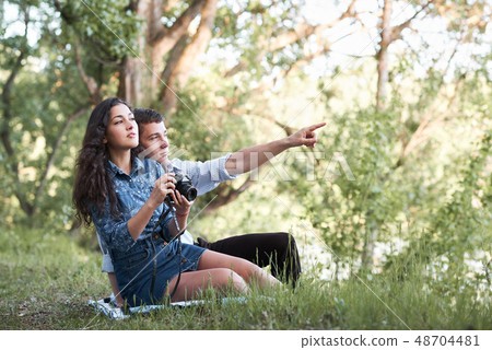 young couple sitting on the grass in the forest, 48704481