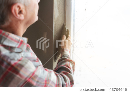 Plasterer working on a window opening 48704646
