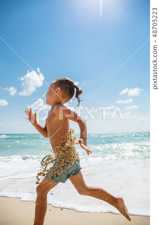 Cute boy is having fun on the beach  48705223