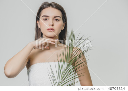 A beautiful young girl in the studio on a white background with wet skin and wet hair holds a large A beautiful young girl in the studio on a white background with wet skin and wet hair holds a large 48705814