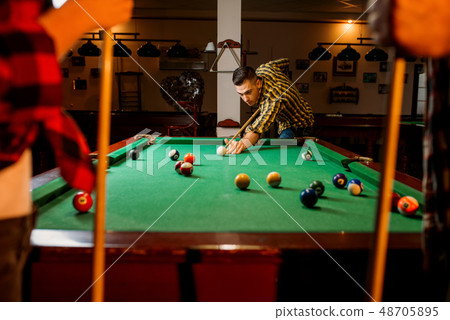Friends plays american billiard in poolroom Friends plays american billiard in poolroom 48705895